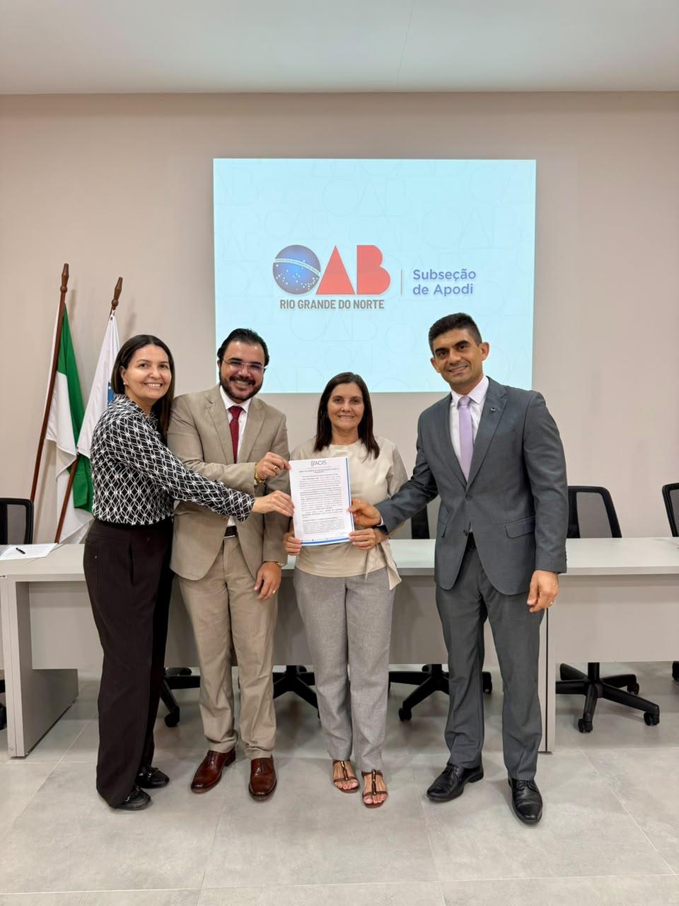 Representantes da FACIS e da OAB Apodi apresentam o documento do convênio assinado